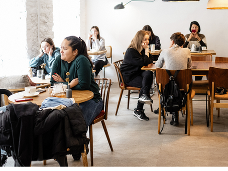 adults enjoying coffee while the kids play