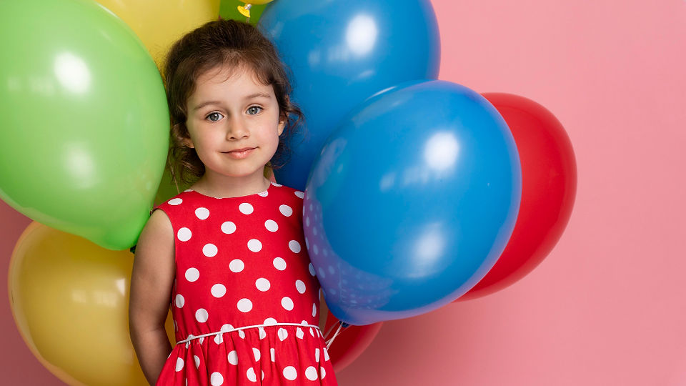 little girl with balloons at a birthday party