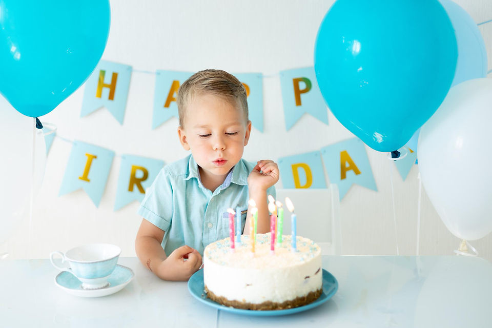 little boy blowing out birthday candles 